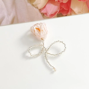 Detailaufnahme von handgefertigten Tulpen-Ohrringen aus rosa Perlen mit bunten Akzenten