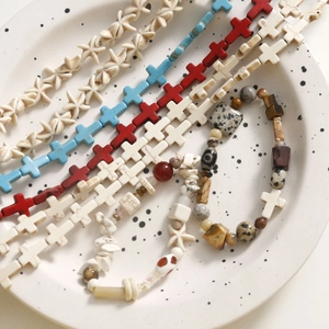 Detailed view of colorful ceramic cross and starfish beads for DIY bracelet jewelry