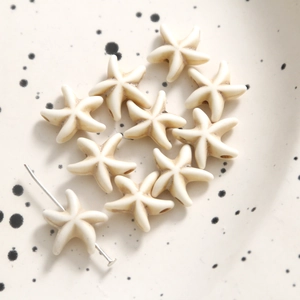 Macro detail of cream starfish beads with center holes for DIY jewelry making