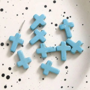 Detail of blue turquoise cross beads for jewelry making showing vertical hole function