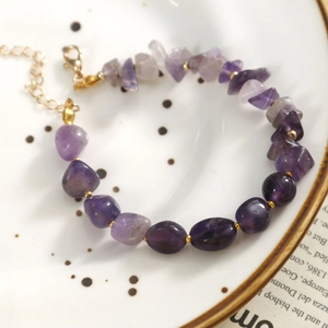 Détail du bracelet en perles de pierre naturelle violette avec fermoir mousqueton doré