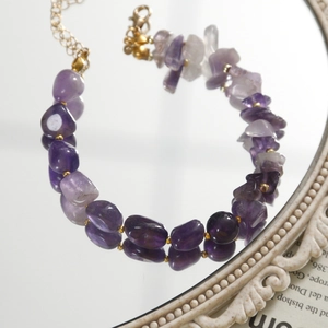 Détail de bracelet en améthyste fait main avec perles dorées et fermoir mousqueton robuste
