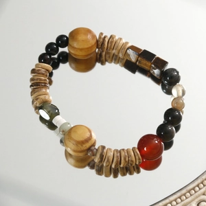 Bracelet ethnique avec œil de tigre, agate et obsidienne sur une surface de miroir polie