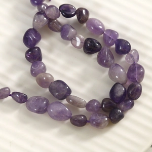 Macro de perles d'améthyste violette naturelle montrant des formes et textures uniques