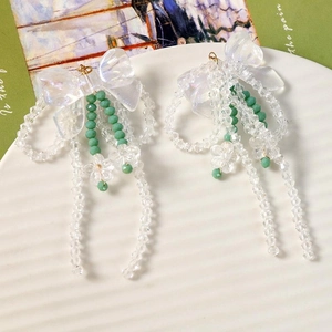 Boucles d'oreilles nœud irisé avec perles fleurs en acrylique et accents verts