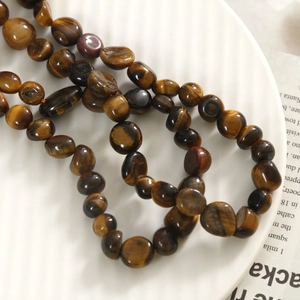 Gros plan de perles naturelles en pierre œil de tigre brun avec effet œil de chat