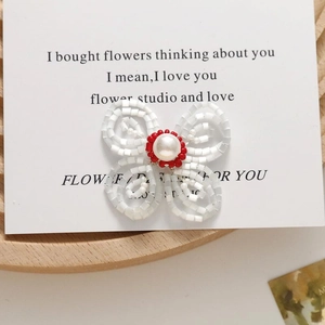 Detailed macro shot of a handmade beaded flower earring with a central pearl accent