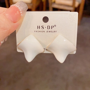 Detailed macro view of irregular square enamel earrings on a 925 silver brand card