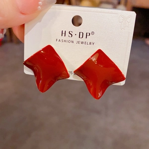 Close-up of red irregular square stud earrings featuring smooth enamel finish and glossy texture