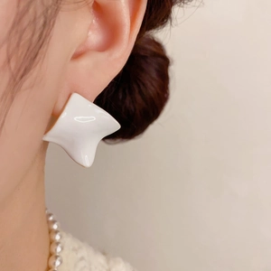 Minimalist white irregular square drop earrings worn by model for an elegant winter look