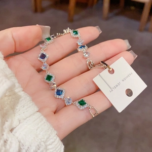 Détail du bracelet en argent avec zircons carrés vert émeraude et bleu profond étincelants