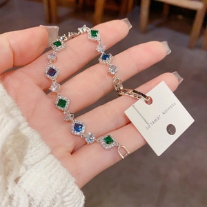 Vue détaillée d'un bracelet en argent avec des pierres de zircone vert émeraude et bleu