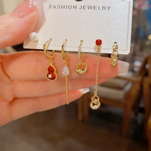 Detail of red gourd and pearl charms on five-piece gold dangling earring set