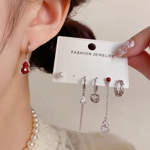 Detail view of red gourd earring and pearl chain set in vintage silver finish