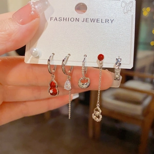 Detailed macro view of a 5-piece earring set featuring red gourd and pearl accents