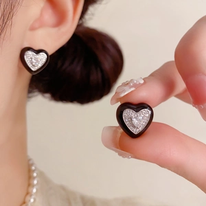 Détails de boucles d'oreilles en cœur avec émail noir et zircons micro-paves