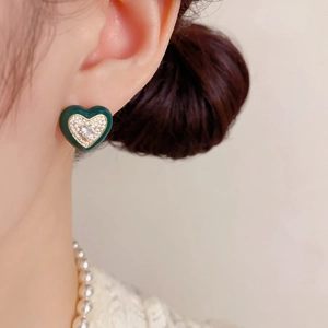 Détail de boucles d'oreilles cœur vintage en émail vert et cristaux étincelants