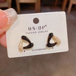 Gros plan détaillé de boucles d'oreilles triangles avec émail noir et zircons brillants