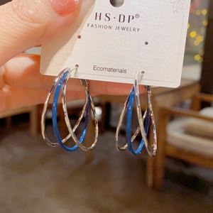 Multi-layer hammered silver and blue enamel hoop earrings on fashion jewelry display card
