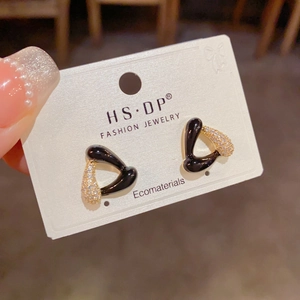 Détail de boucles d'oreilles triangulaires avec émail noir et zircons brillants