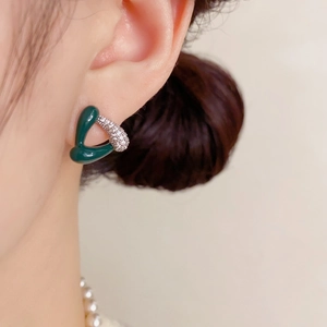 Gros plan de boucles d'oreilles triangulaires en émail vert avec zircons