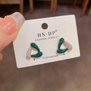 Détail de boucles d'oreilles triangles vert foncé avec micro-pierres sur carte