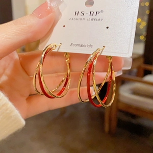 Detail of red enamel layered hoop earrings featuring 18k gold plating on display card