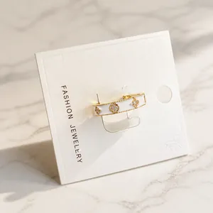 Détail d'une bague trèfle en émail blanc avec incrustation de zircon sur carte de bijoux