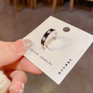 Vue détaillée d'une bague fleur argentée avec émail noir et micro-diamants