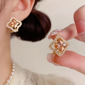 Détail macro de boucles d'oreilles en or avec cristal champagne et incrustations de zircon