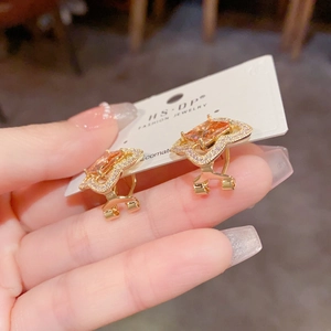 Détail de boucles d'oreilles florales avec gemmes champagne et micro-pavé de zircons
