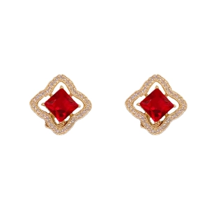 Boucles d'oreilles dorées avec zircon rouge carré et cristaux blancs sur fond blanc pur