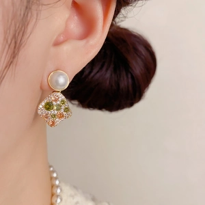 Detail of drop earring with white pearl and multi-color pavé zircon rhombus pendant