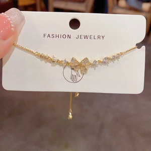 Macro shot of gold bow bracelet with white zircon and adjustable sliding clasp closure