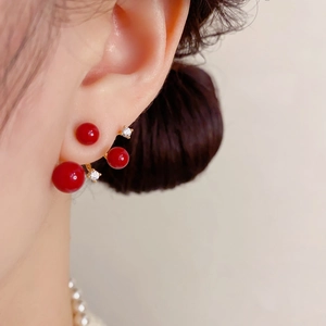 Elegant red pearl and rhinestone drop earrings in gold finish worn by a model