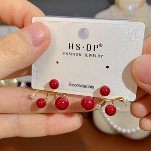 Elegant red pearl and rhinestone stud earrings on a display card for women