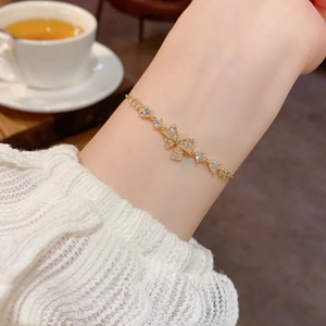 Close-up of elegant gold bow bracelet with micro-pave zircons worn on female wrist