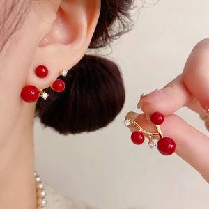 Detail of red pearl cherry earrings with gold branches and micro-set cubic zirconia stones