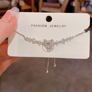 Detailed view of silver bow bracelet with micro-pave cubic zirconia on display card