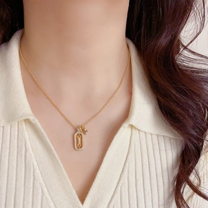 Close-up of gold starburst necklace with zircon embellishment on model's neck