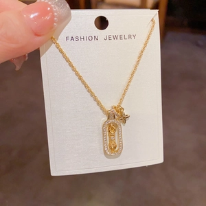 Detailed shot of gold star necklace with zircon pendant on fashion display card