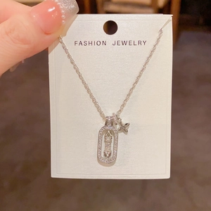 Detail of square star necklace with micro-paved zircons and a small clover charm