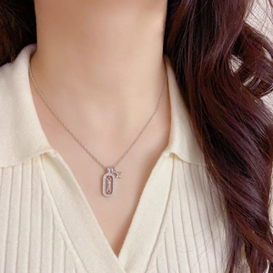 Close-up of a silver necklace with square hollow frame and four-pointed star pendant