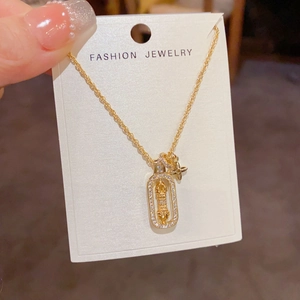 Close-up of gold star pendant necklace with cubic zirconia and floral charm detail