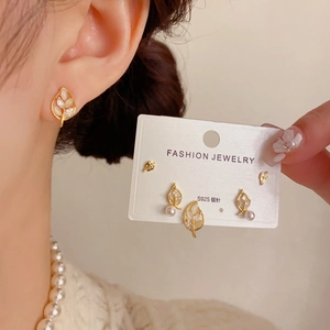 Detailed view of S925 silver leaf earrings set with pearls and crystals on a display card