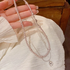Détail d'un collier double épaisseur avec perles lavande et pendentif cristal rond