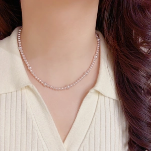Gros plan détaillé d'un collier de perles double couche avec pendentif géométrique