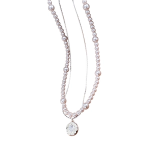 Collier double rang en perles et chaîne avec un pendentif rond gravé d'un cœur