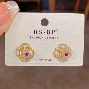 Detalle de pendientes Fu dorados con piedra roja y circonitas, poste de plata S925