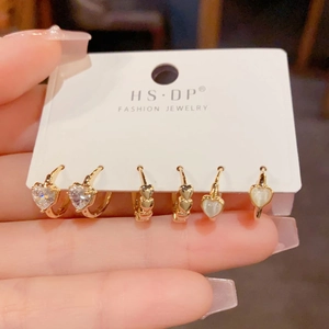 Set di tre paia di orecchini a cuore dorati con zircone e dettagli in opale bianco